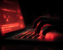 Main d’un homme tapant sur un clavier d’ordinateur avec à l’écran des alertes rouges signalant une cyberattaque.